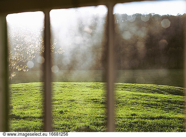 Fall sunlight on a field through a farmhouse window.