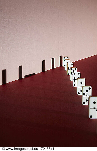 Fallen domino shadow on red background