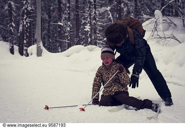 fallen fallend fällt Europäer Menschlicher Vater Hilfe Skisport Tochter querfeldein Cross Country Schnee