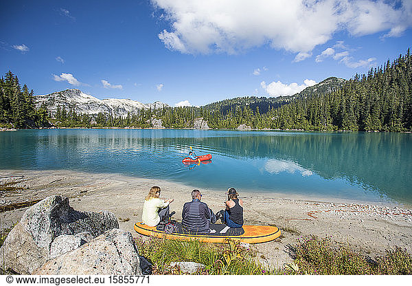 Familie entspannt gemeinsam am abgelegenen See  Bruder paddelt auf dem See.