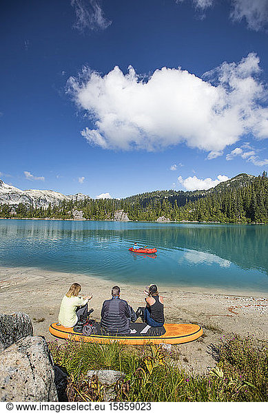 Familie entspannt gemeinsam am abgelegenen See  Bruder paddelt auf dem See.