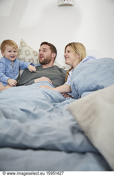 Familie entspannt gemeinsam im Bett