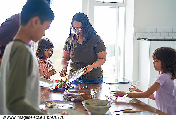 Familie räumt Essen und Geschirr vom Mittagstisch