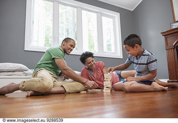 Familie spielt ein Spiel im Wohnzimmer.