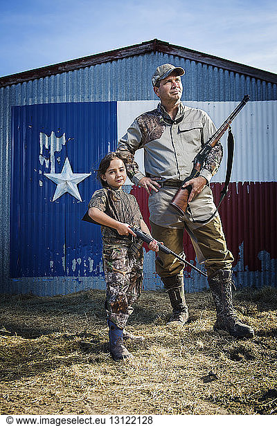 Familie steht auf Feld mit Gewehr gegen Texas-Flagge