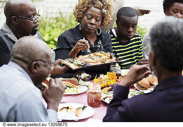 Familie und Freunde essen Essen  während sie am Tisch sitzen
