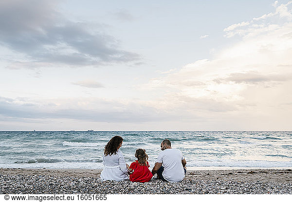 Familie verbringt Zeit am Strand bei bewölktem Himmel
