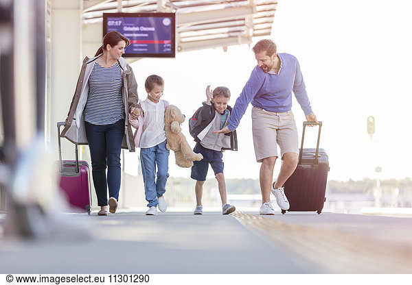 Familienwandern und Koffer ziehen am Bahnhof