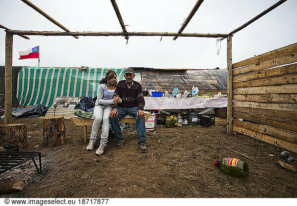 Families comfort each other at make shift camps in the highlands in Chile. Residents are afraid to return home especially after hearing of yet  another  tsunami warning. Here they