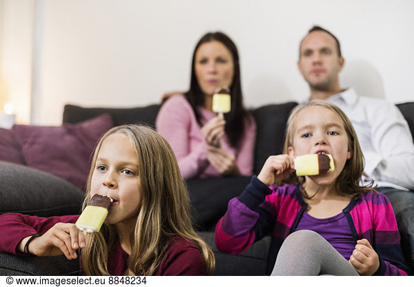 Family eating ice cream in living room