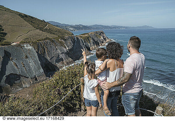 Family enjoying view at observation point against sky during sunny day