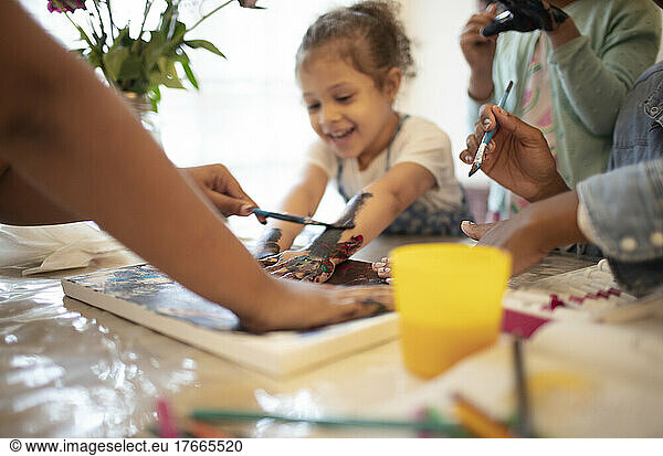 Family finger painting at table