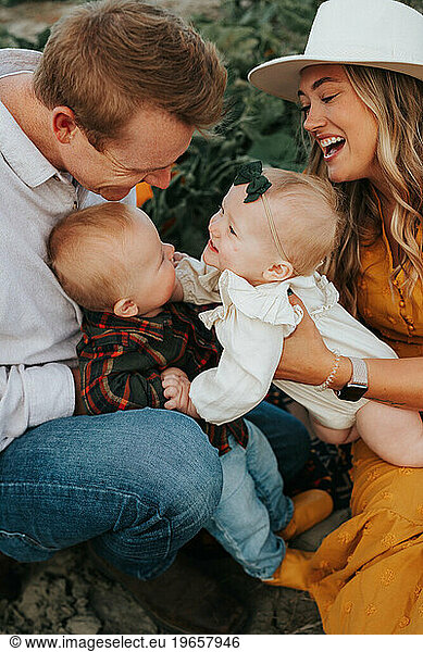 Family fun in pumpkin patch  laughter fills air.'