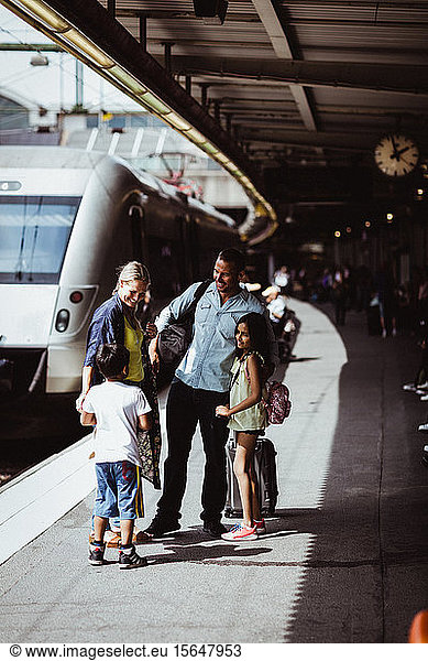 Family greeting man at railroad station