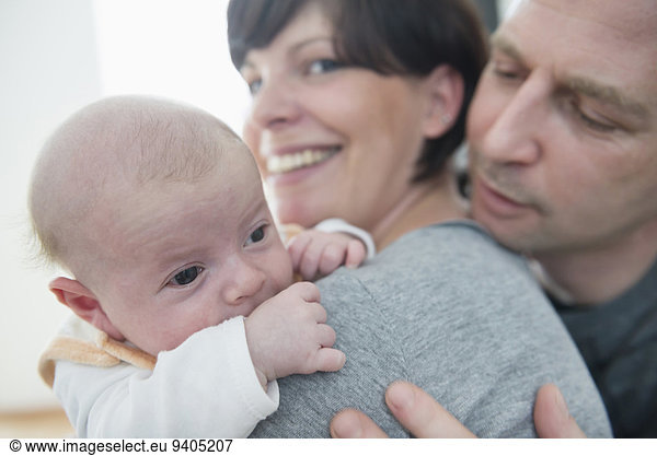 Family holding baby boy  smiling  close up