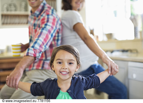 Family holding hands in kitchen