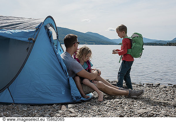 family hugging and exploring camping by the water in Norway