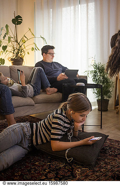 Family is using technologies in living room at smart home