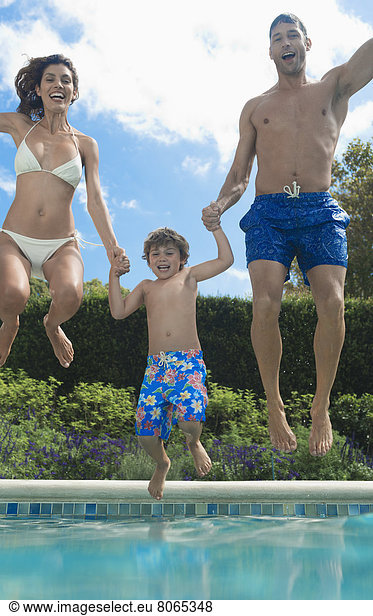 Family jumping into swimming pool