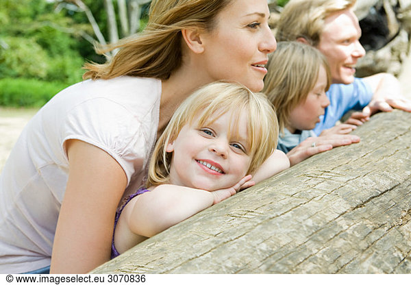 Family leaning on a log
