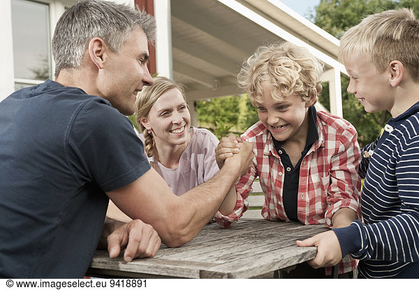 Family mother father kids boy arm wrestling