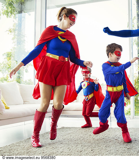 Family of superheroes playing in living room