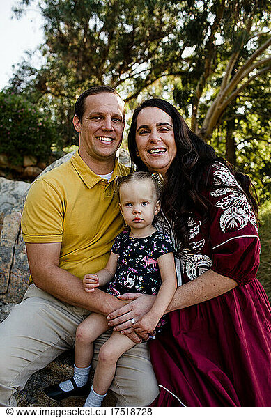Family of Three Smiling for Camera in Garden in California