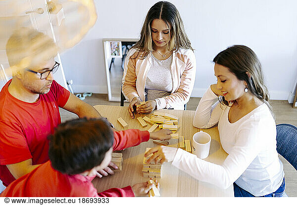 Family playing block removal game on table at home