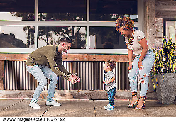 Family playing in Downtown  baby boy walking to dad