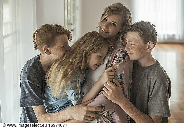 Family portrait of beautiful family with red hair embracing in studio