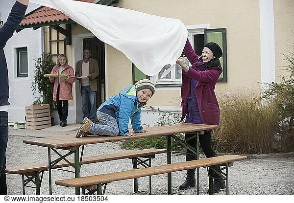 Family preparing a picnic table outside at farmhouse  Bavaria  Germany