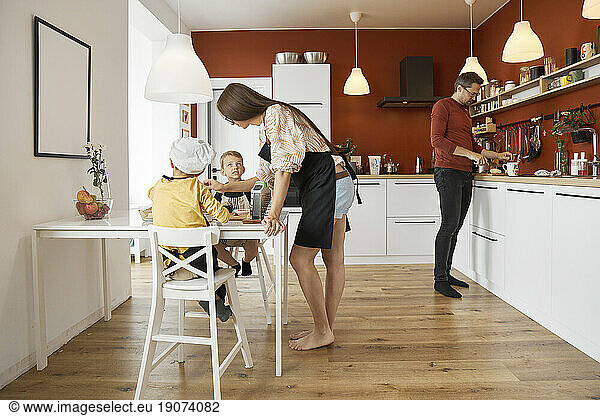 Family preparing food together in kitchen at home