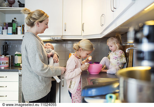 Family preparing pancake in domestic kitchen