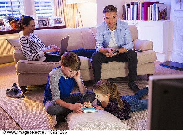 Family relaxing with technology in living room