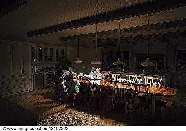 Family sitting at illuminated dining table