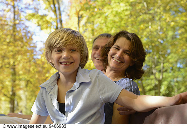 Family sitting on bench  smiling  portrait