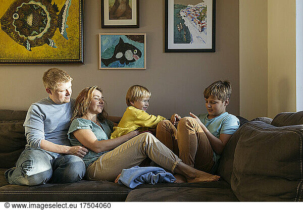 Family sitting on sofa at home
