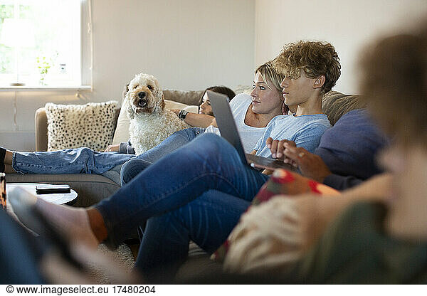Family sitting together on sofa in living room at home
