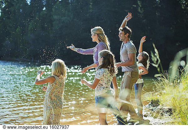 Family skipping stones at lakeside