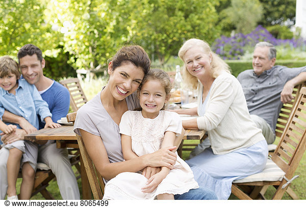 Family smiling at table outdoors