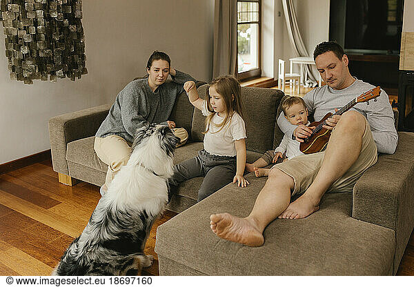 Family spending leisure time in living room at home