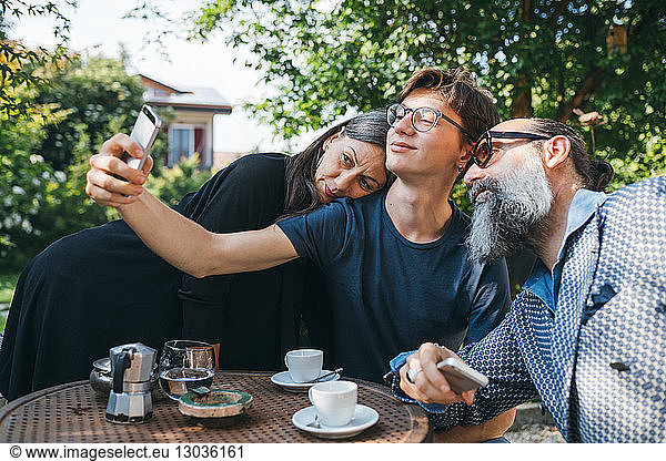 Family taking selfie over coffee in patio