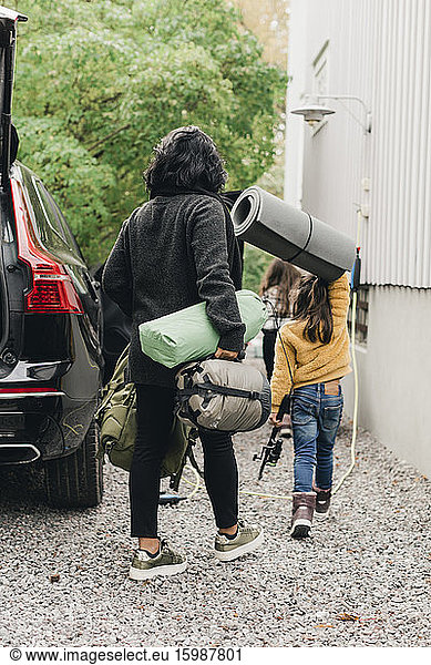 Family unloading luggage from electric car