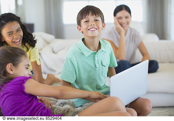 Family using laptop on sofa in living room