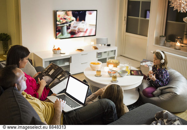 Family using technologies in living room