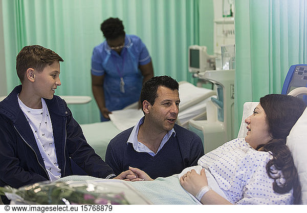 Family visiting  talking with patient in hospital ward