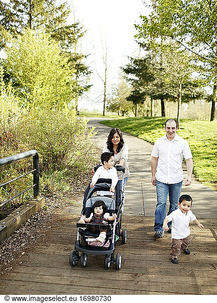 Family walking across park bridge