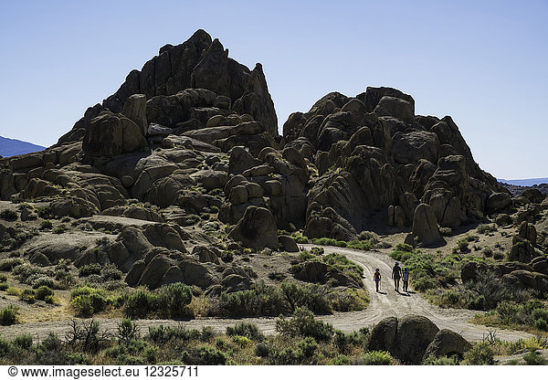 Family walking down a road in the Alabama Hills; California  United States of America