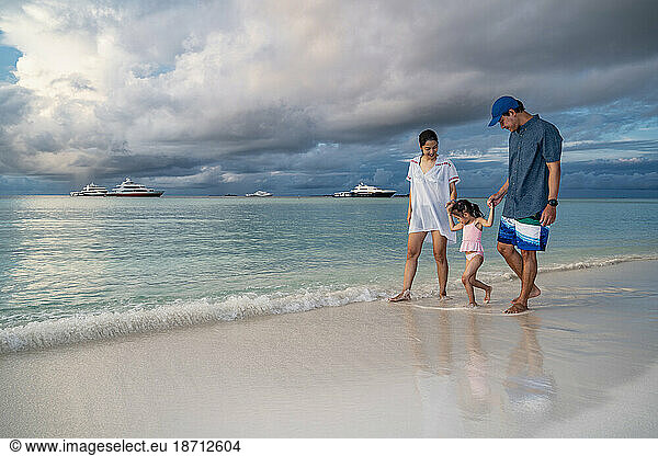 family walking on a beach in the Maldives