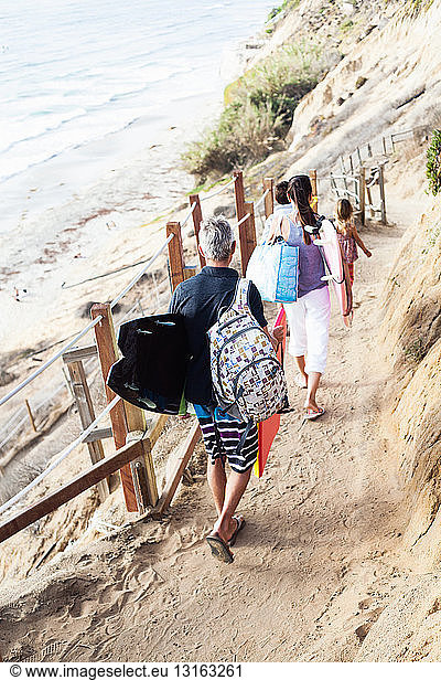 Family walking to beach with surfboards  Encinitas  California  USA